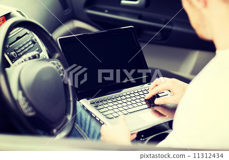 man using laptop computer in car man using laptop computer in car 11312434
