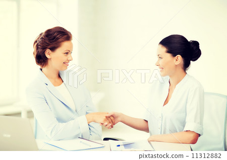 businesswomen shaking hands in office businesswomen shaking hands in office 11312882