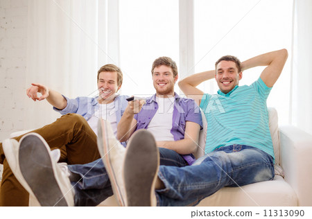 smiling friends with remote control at home 11313090