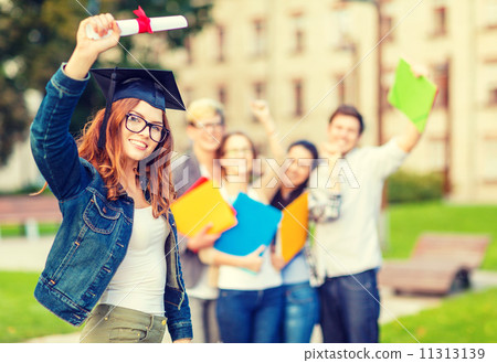 smiling teenage girl in corner-cap with diploma 11313139