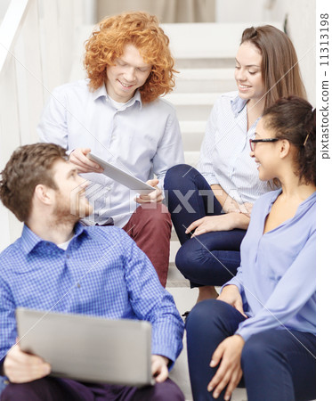team with laptop and tablet pc on staircase 11313198