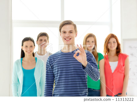 students with teenager in front showing ok sign 11313222