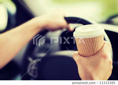 man drinking coffee while driving the car 11313389