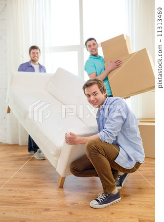 smiling friends with sofa and boxes at new home smiling friends with sofa and boxes at new home 11313469