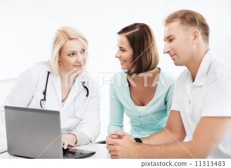 doctor with patients looking at laptop 11313483