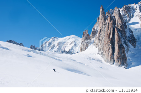 Skier goes downhill on a alpine glacier 11313914