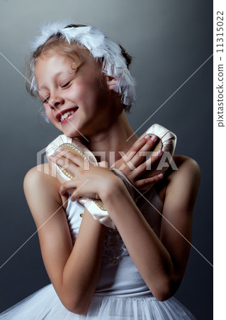 Portrait of happy little ballerina cuddles pointes Portrait of happy little ballerina cuddles pointes 11315022