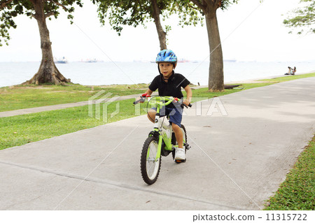 A boy riding a bicycle 11315722
