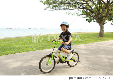 A boy riding a bicycle 11315724