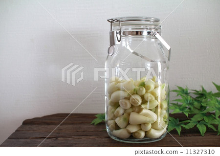 Peeled and pre-processed organic shallots in a storage jar 11327310