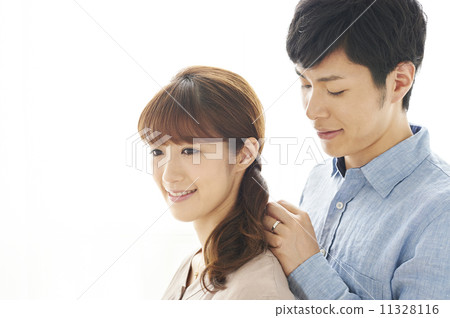 A man wearing a necklace on a neck of a woman 11328116