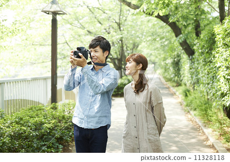 Men and women taking pictures with cameras and walking 11328118