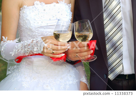 glasses with champagne in the hands of groom and fiancee 11338373