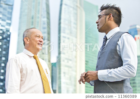 Young executive talking casually to senior executive Young executive talking casually to senior executive 11360389