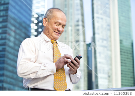 Elderly businessman making a call on smart phone Elderly businessman making a call on smart phone 11360398