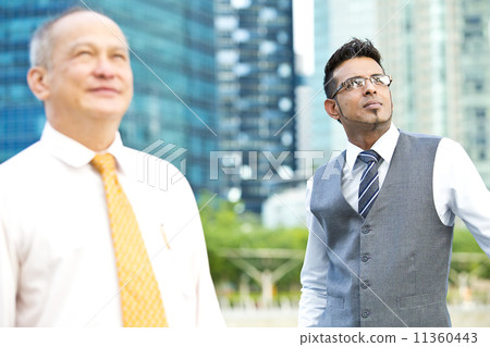 Senior executive looking at a direction while young executive at background Senior executive looking at a direction while young executive at background 11360443