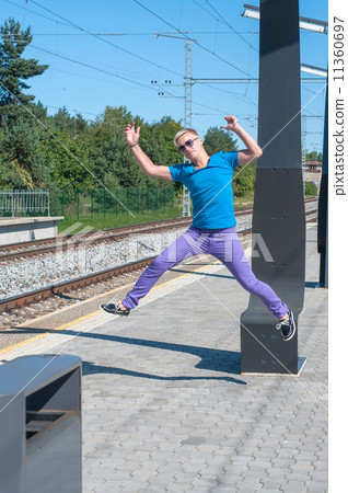 Handsome young guy jumping on train station 11360697