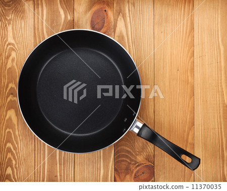 Frying pan on wooden table 11370035