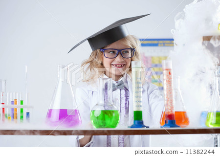 Smiling little chemist puts experiments in lab 11382244