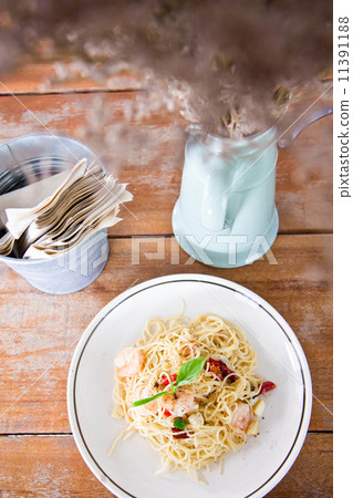 Chilli prawn spaghetti on wooden table in restaurant Chilli prawn spaghetti on wooden table in restaurant 11391188