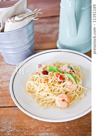 Chilli prawn spaghetti on wooden table in restaurant Chilli prawn spaghetti on wooden table in restaurant 11391189