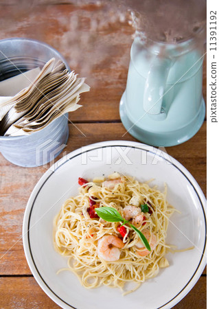 Chilli prawn spaghetti on wooden table in restaurant Chilli prawn spaghetti on wooden table in restaurant 11391192