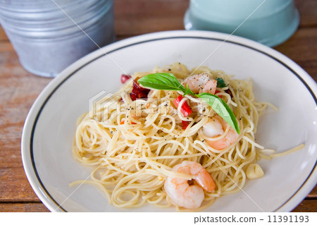 Chilli prawn spaghetti on wooden table in restaurant 11391193