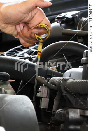 Mechanic check the oil in the engine Mechanic check the oil in the engine 11396407