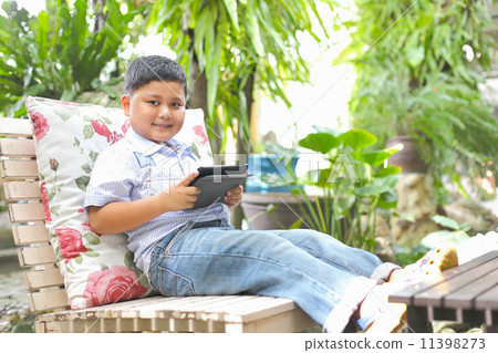 Asian boy playing tablet at the park 11398273