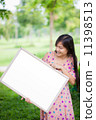 Portrait of young woman with blank white board 11398513