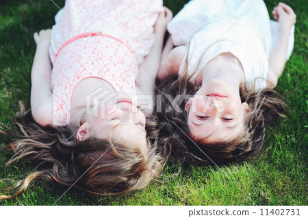 Two best friends laying together on lawn 11402731