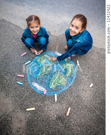 smiling girls drawing Earth with chalks on street 11412422