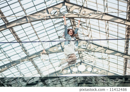 happy woman jumping up high at airport 11412486
