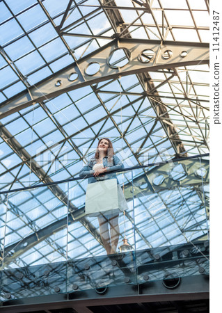 woman standing on balcony at railway station with glass ceiling 11412487