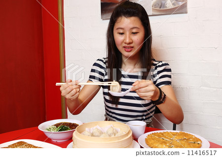 A woman eating dumpling 11416517