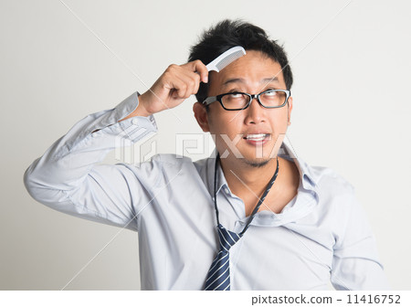 Asian businessman combing hair 11416752