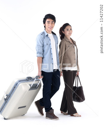 Young couple pulling a luggage Young couple pulling a luggage 11427202