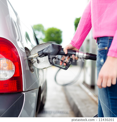 Lady pumping gasoline fuel in car at gas station. Lady pumping gasoline fuel in car at gas station. 11430201
