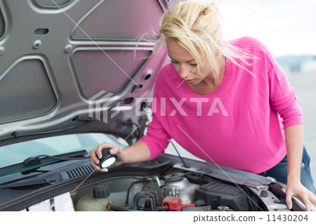 Woman inspecting broken car engine. Woman inspecting broken car engine. 11430204