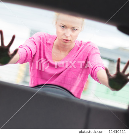 Woman pushing a car. 11430211