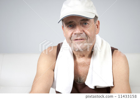 Adult male relaxes after exercising in the fitness gym. 11433158