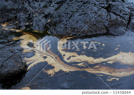 crude oil spill on the stone at the beach 11438844