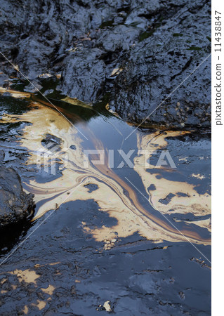crude oil spill on the stone at the beach crude oil spill on the stone at the beach 11438847