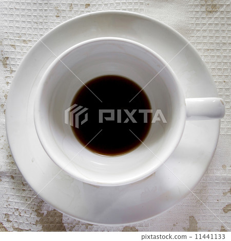 Coffee cup over white tablecloth background. Dregs in the bottom Coffee cup over white tablecloth background. Dregs in the bottom 11441133
