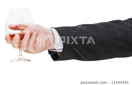 side view of brandy glass in businessman hand 11444491
