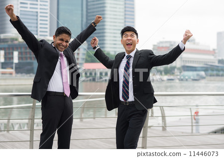 Two multi-ethnic young businessmen cum partners overjoyed by success 11446073