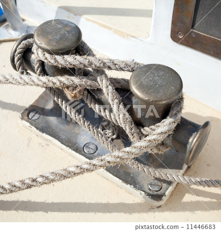 Dark bollard with rope knot on yacht deck 11446683