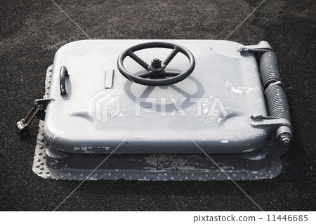 Old gray locked hatch on black ship deck 11446685