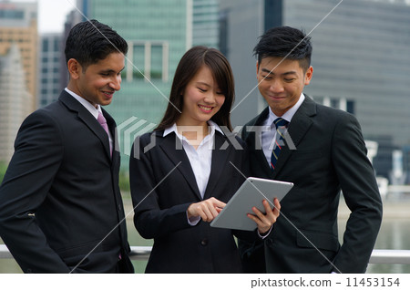 A young and multi-ethnic team sharing information using a digital tablet (Landscape) A young and multi-ethnic team sharing information using a digital tablet (Landscape) 11453154