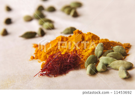 Green cardamom pods, saffron and turmeric powder on cloth 11453692